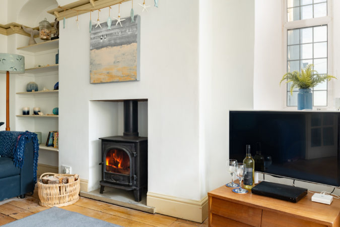 Living room with wood burner in cottage at Sandsend