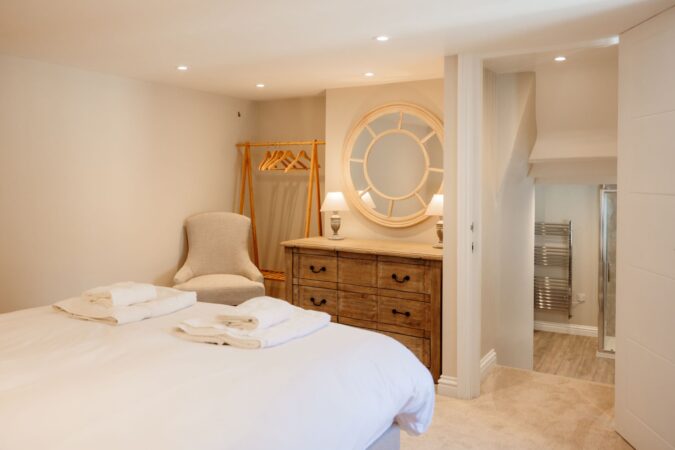 Spacious king-size bedroom with crisp white linens and cozy decor at The Hideaway