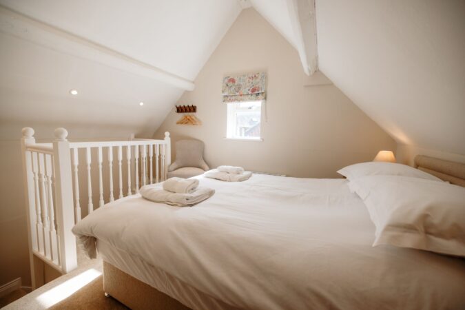 Loft king-size bedroom with sloped ceilings at The Hideaway holiday cottage